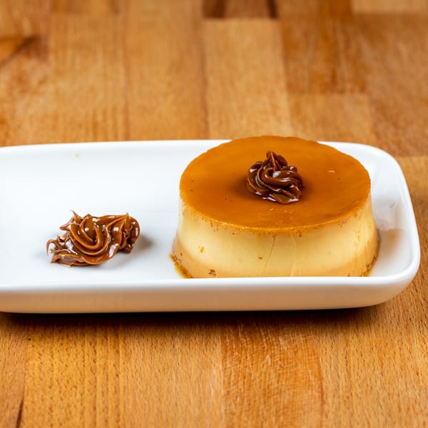 A Salvadoran flan dessert with caramel topping and a dollop of dulce de leche.
